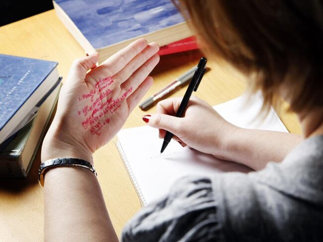 25/08/2008 FEATURES: A student cheats in an exam by writing on the palm of her hand. Cheating. Books. Pen. Paper. Cheat.