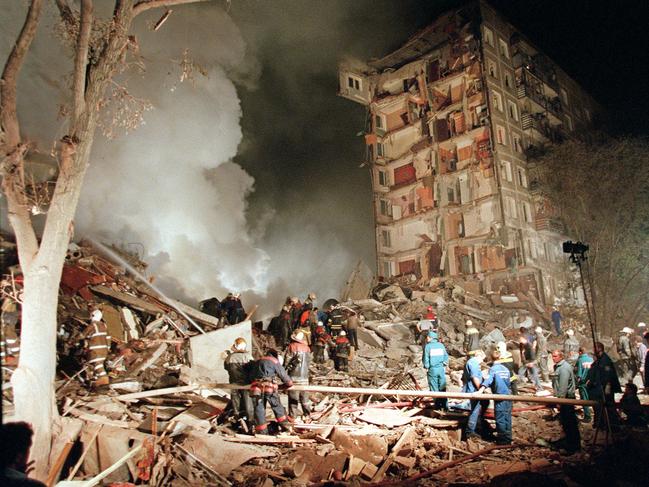 Smoke rises from a destroyed apartment building as Russian Emergency Situations Ministry officers and firefighters try to save people in Moscow in 1999.