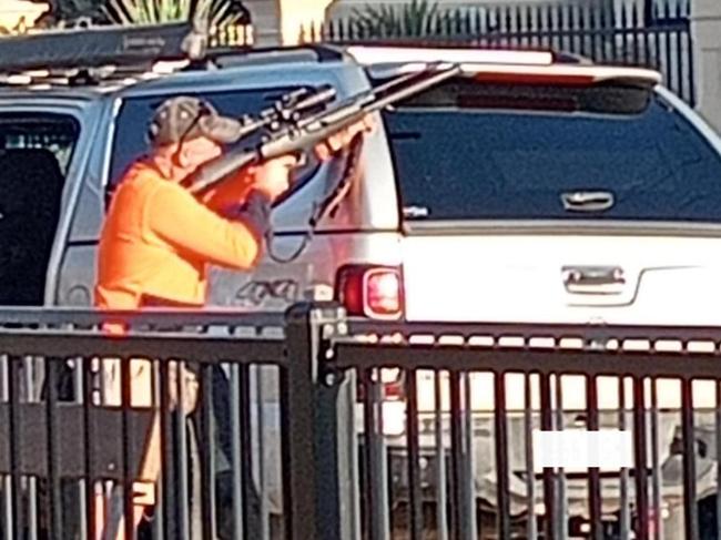 A photograph has emerged online of a man pulling out a gun next to a playground in Brighton, sparking panic among some residents.Brighton local, Jeff, said he was surprised (and relieved) to discover the man was undergoing an authorised pigeon cull in the area with an air rifle, but was “taken aback” by what he saw. Picture: 10 News First Adelaide