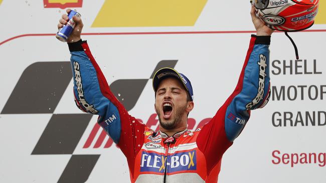 Italy's MotoGP rider Andrea Dovizioso cerebrates after winning the race of the Malaysia MotoGP at the Sepang International circuit in Sepang, Malaysia, Sunday, Oct. 29, 2017. (AP Photo/Vincent Thian)