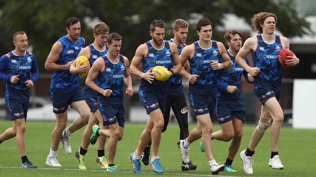 North Melbourne players warm up at Arden Street yesterday