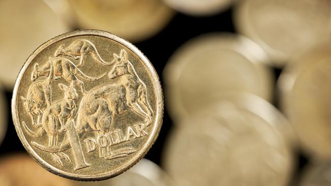 Australian one dollar coin over blurred golden background.