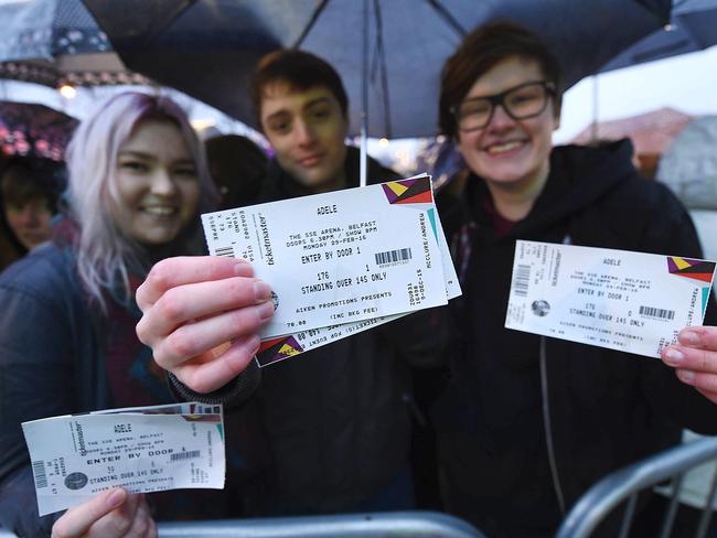 Dedicated ... fans brandish their lucky tickets to the superstar’s show.