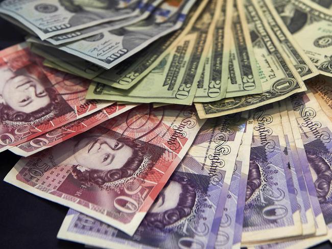 (FILES) This file photo taken on October 04, 2016 shows a cashier displaying multiple denomination US dollar and British pound Sterling bank notes for a photograph inside a currency exchange store in central London on October 4, 2016. The pound suffered a "flash crash" in Asia on October 7, 2016 in a computer-generated sell-off in the beleaguered currency, as tough talk from French President Francois Hollande underscored the perils ahead for Brexit-bound Britain. / AFP PHOTO / NIKLAS HALLE'N