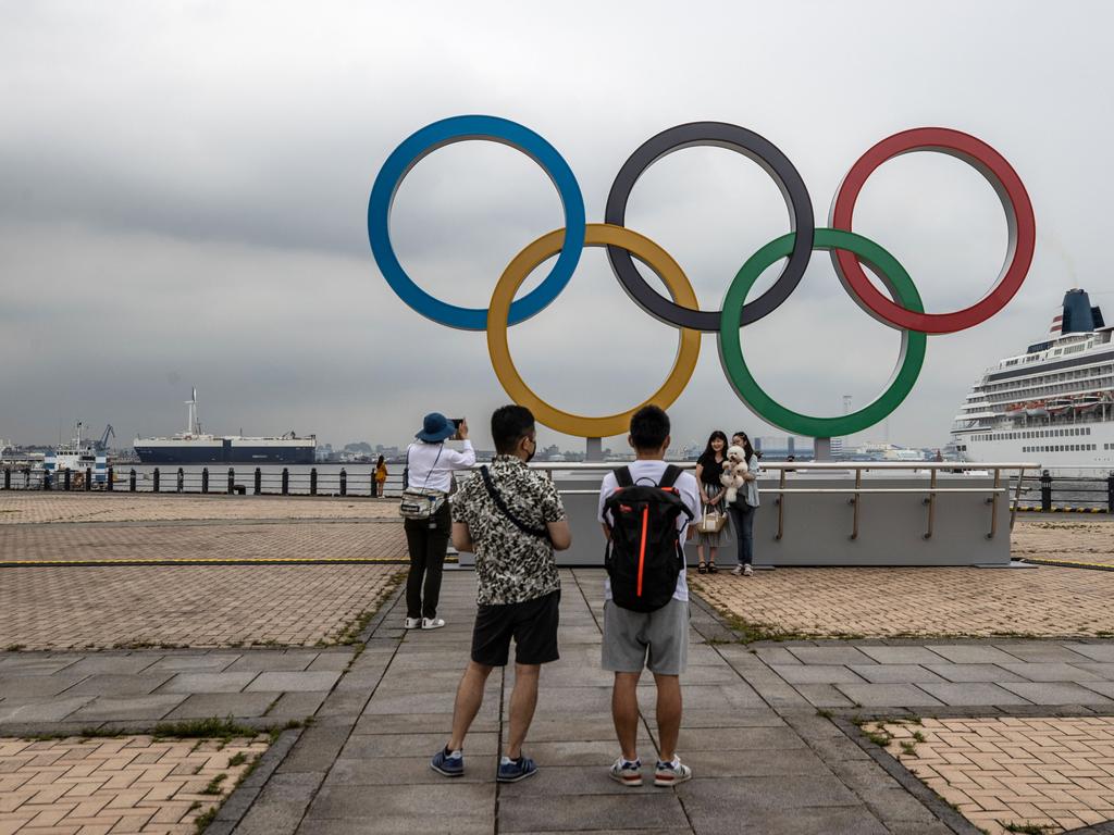 People take photographs of the Olympic Rings at Akarenga Park.