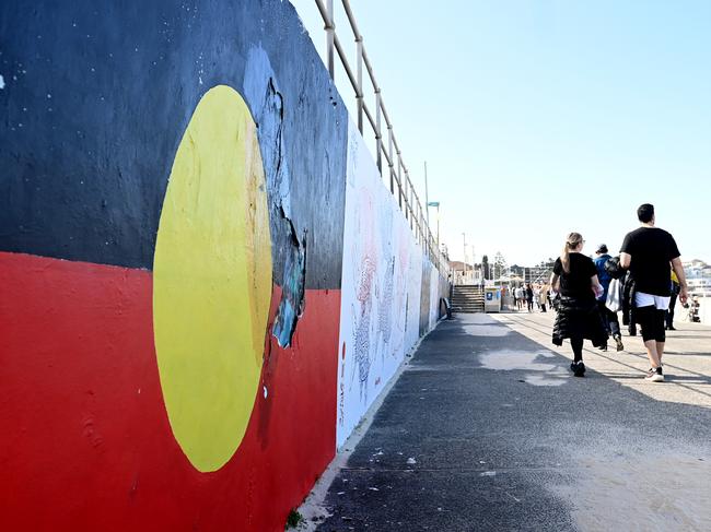 SYDNEY, AUSTRALIA - NewsWire Photos JULY 30, 2022: The Aboriginal Flag is painted on the promenade at Bondi Beach. Prime Minister Anthony Albanese will unveil a draft question that Australians could be asked during a referendum to create an Indigenous Voice in the nation's constitution.Picture: NCA NewsWire / Jeremy Piper