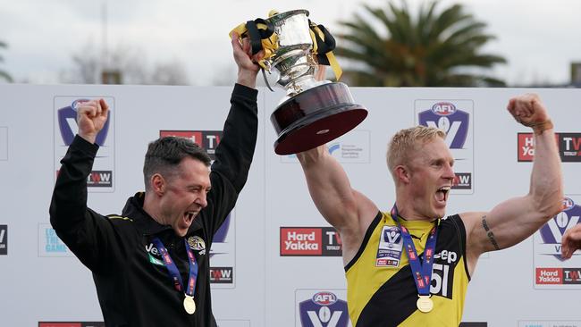 Senior coach in waiting Craig McRae, left, and Steve Morris hold up the VFL premiership cup for Richmond at Ikon Park on September 22, 2019.