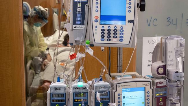 Intravenous therapy (IV) equipment hangs outside a COVID-19 patient's door in a Stamford Hospital Intensive Care Unit.