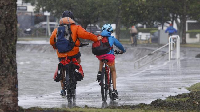 Cyclists battle the wind and rain on the foreshore in Wynnum, on Brisbane’s bayside, earlier this month. Picture: NCA NewsWire/Tertius Pickard