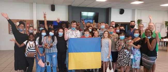 The Renkas family with the Ukrainian flag and their supporters at C3 Church, Darwin.