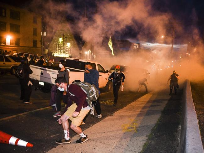 People run from tear gas thrown by the police near the Colorado State Capitol. Picture: Michael Ciaglo