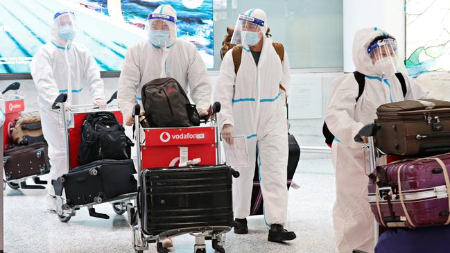 People in full PPE arriving at Sydney International Airport. Picture: Adam Yip