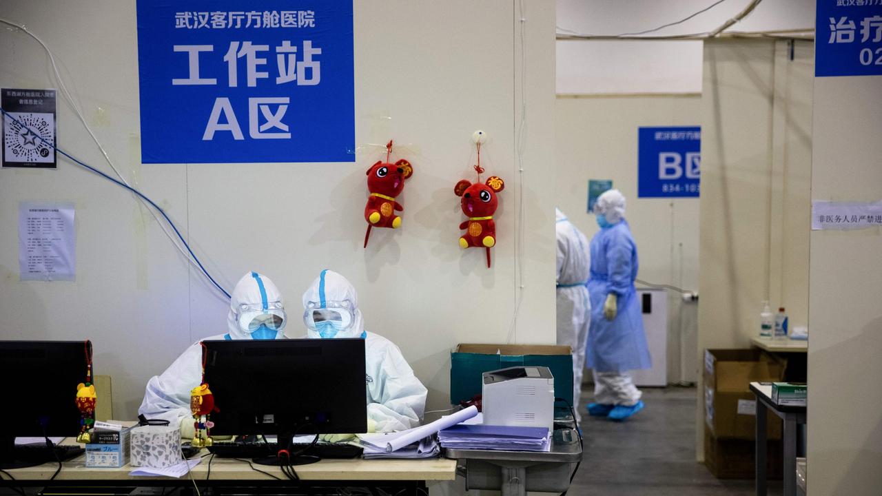 Medical staff at an exhibition centre converted into a hospital in Wuhan, China where police are preparing to conduct checks of all nine million residents. Picture: AFP