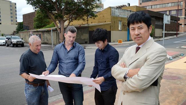 (L-R) Architects Paul Jones and Caine King with developers Jun Wang and Jian Wang (left) were unaware of the asbestos buried under the buildings set for demolition behind them.