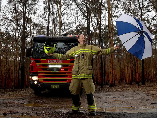 Fire and Rescue NSW Nowra firefighter Dave Holman in the now damp fire ground on Forest Rd in Comberton. Picture: Toby Zerna