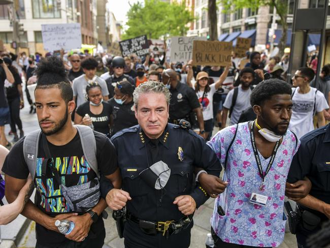 Denver Police Chief Paul Pazen (C) links arms with people protesting the death of George Floyd, in Denver, Colorado. Picture: AFP