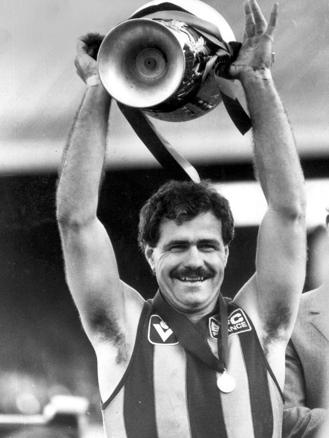 Leigh Matthews hoists the 1983 VFL premiership cup.