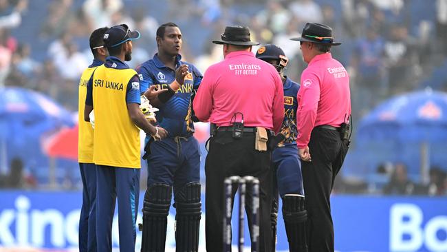 Sri Lanka's Angelo Mathews speaks with the umpires after he was timed out. (Photo by Sajjad HUSSAIN / AFP).