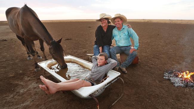 Horse breakers Anthony and Cassie Jessup with son Shane enjoy the relative cool of the evening on their property near Winton, Queensland. Picture: Lyndon Mechielsen