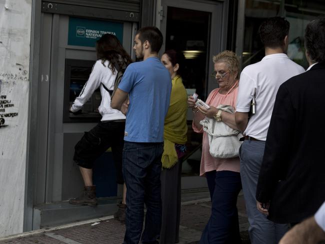 People line up at an ATM outside a branch of the National Bank, in central Athens, on Friday, June 19, 2015. Greece failed to secure a deal with bailout creditors on Friday, prompting the European Union to calls an emergency leaders' meeting for Monday. (AP Photo/Petros Giannakouris)