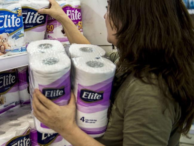 A woman buys toilet paper at a supermarket in Santiago on October 29, 2015. The biggest producers of toilet paper and napkins of Chile shared the market and set prices for a decade, in a new corruption case that has outraged Chilean consumers. The companies CMPC Tissue and SCA Chile, controlling 90% of the market for toilet tissue, are under investigation by the National Economic Prosecutor (FNE). AFP PHOTO / MARTIN BERNETTI