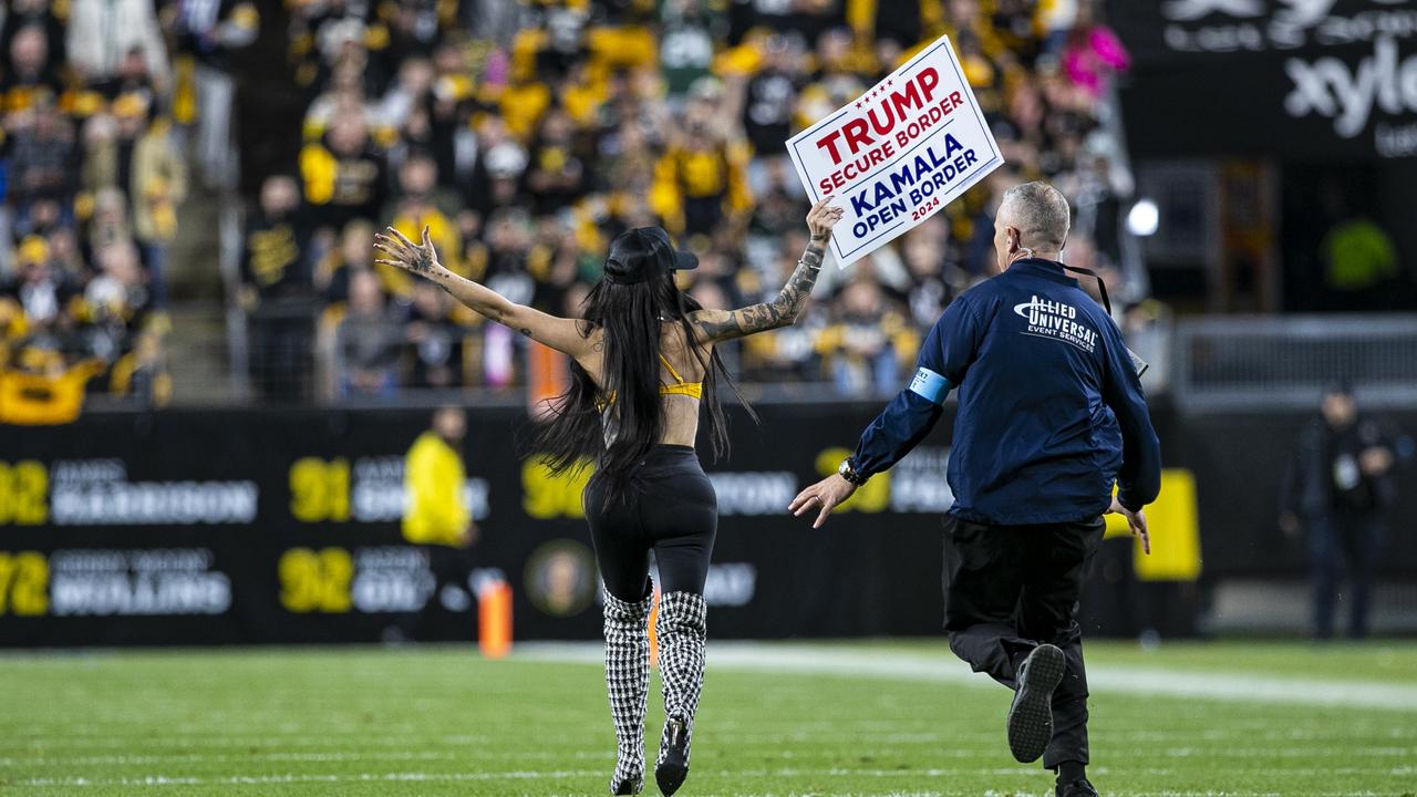 Claudia Rose runs across the field with a Donald Trump sign. Photo by Mark Alberti/Icon Sportswire via Getty Images.