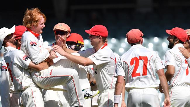 Redback players lift Lloyd Pope after taking his 5th wicket during day one of the round two JLT Sheffield Shield match between South Australia and Queensland at Adelaide Oval in Adelaide. Picture: AAP/David Mariuz.