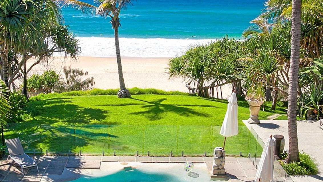 The property overlooks Sunshine Beach, as the backyard lawn meets the sand.