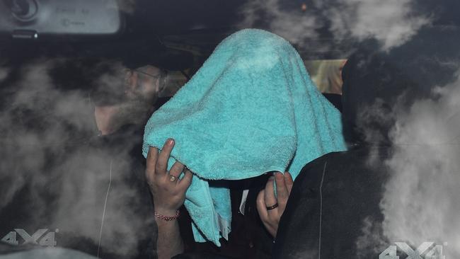 Lawrence took refuge under a towel as she waited in the car for her luggage and other family members at Newcastle Airport. Picture: Dan Himbrechts/AAP