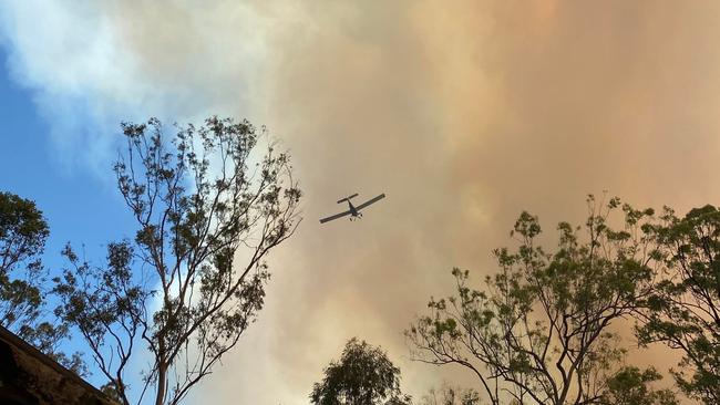 Smoke spreads through the sky as an aircraft contains the blaze on Billabong Lane, Tara. Picture: contributed/Michelle Cullen