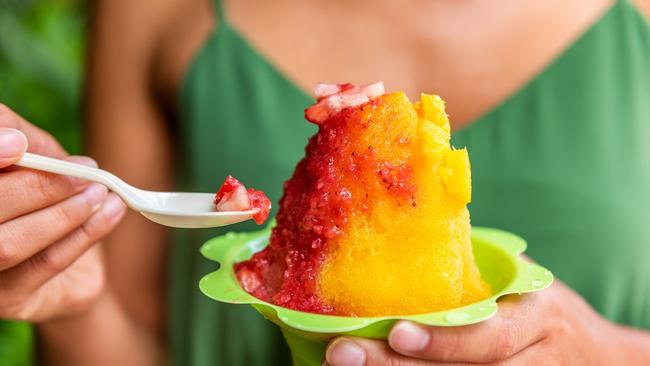 Shave Ice Hawaii local food woman eating hawaiian shaved ice cream treat in Honolulu Waikiki beach, Hawaii, USA.Photo - istockEscape 25 June 2023Hawaii