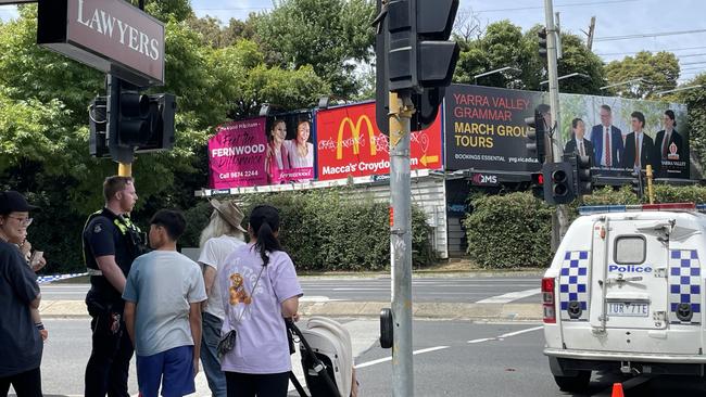 Bystanders talking to police following the shutdown of part of Maroondah Highway near Eastland due to a bomb threat. Picture: Kiel Egging