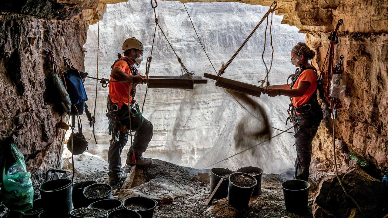 Archaeologists Hagay Hamer (L) and Oriah Amichai sifting soil during excavations in the cave. Picture: Eitan Klein/Israeli Antiquities Authority/AFP