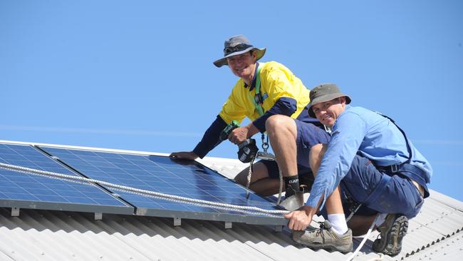 Electricians install roof top solar panels.