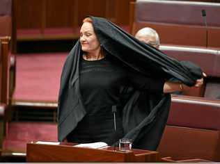 One Nation Senator Pauline Hanson takes off a burqa during Senate Question Time at Parliament House in Canberra, Thursday, August 17, 2017. Picture: LUKAS COCH