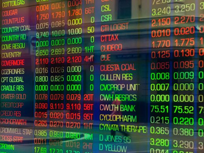 Sydney, Australia - March 5, 2014: An office worker crossing a road is reflected in the glass display of a trading screen at the Australian Stock Exchange on Bridge Street.