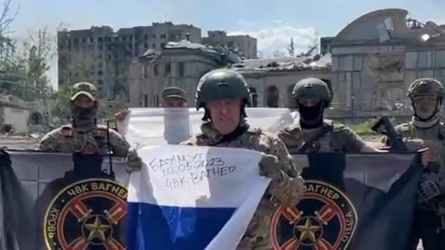 Yevgeny Prigozhin holds a Russian national flag in front of his soldiers holding Wagner Group's flags in Bakhmut. Picture: AFP.