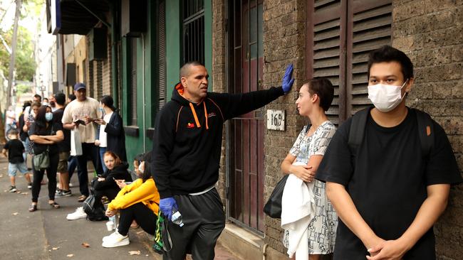 Anthony Mundine handing out waters to people in the Darlinghurst Centrelink queue to provide support for those who are now unemployed as a result of the CV19 pandemic. Picture. Phil Hillyard