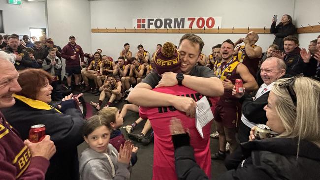 Premiership coach Michael Kinsella gives Liam Wilson, the former coach, a premiership medallion to a roaring reception.