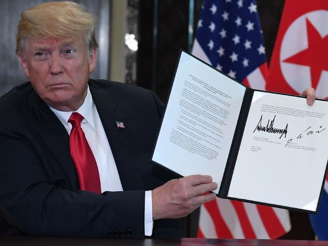 US President Donald Trump holds up the  document signed by him and North Korea's leader Kim Jong-un.