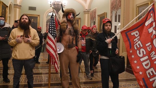 Donald Trump supporters including member of the QAnon conspiracy group Jake Angeli, aka Yellowstone Wolf, centre, enter the US Capitol on January 6 last year. Picture: AFP