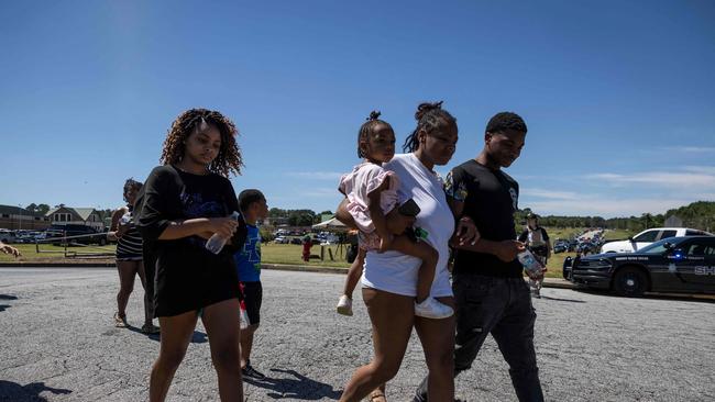 Parents and students leave the scene after being reunited. Picture: AFP