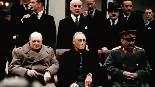 Soviet leader Stalin, American President Roosevelt and British Prime Minister Churchill seated together during the Yalta Conference, 1945. Behind them stand their respective foreign ministers; Molotov, Stettinius and Eden.