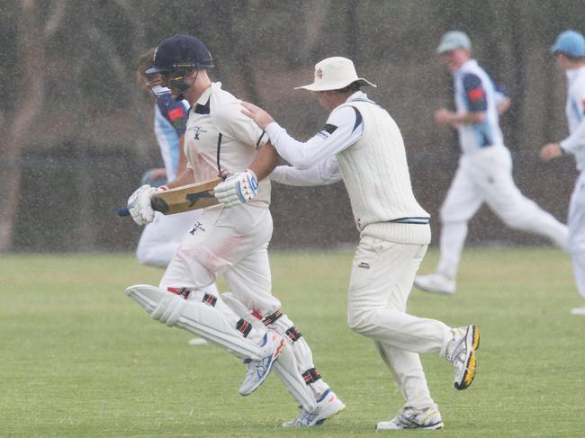 Players scurry from the ground as rain falls. Picture: Mark Wilson