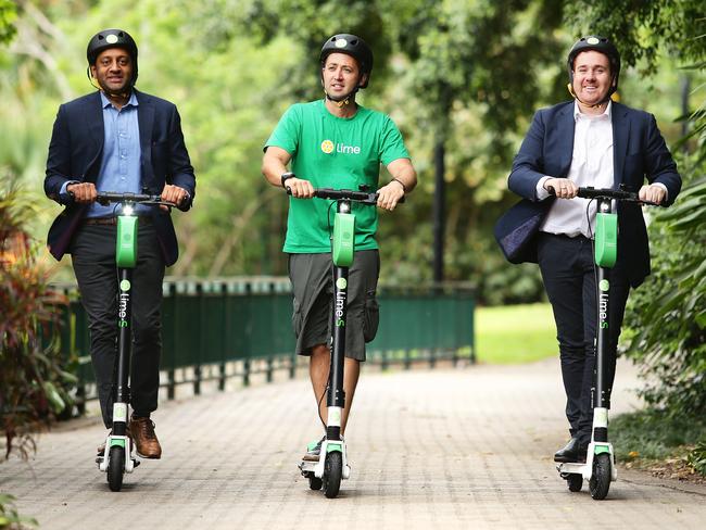 Mayank Mittal, Vinicius Machado Campos and Mitchell Price ride LIME e-scooters at Brisbane Botanical Gardens. Picture: AAP/Claudia Baxter