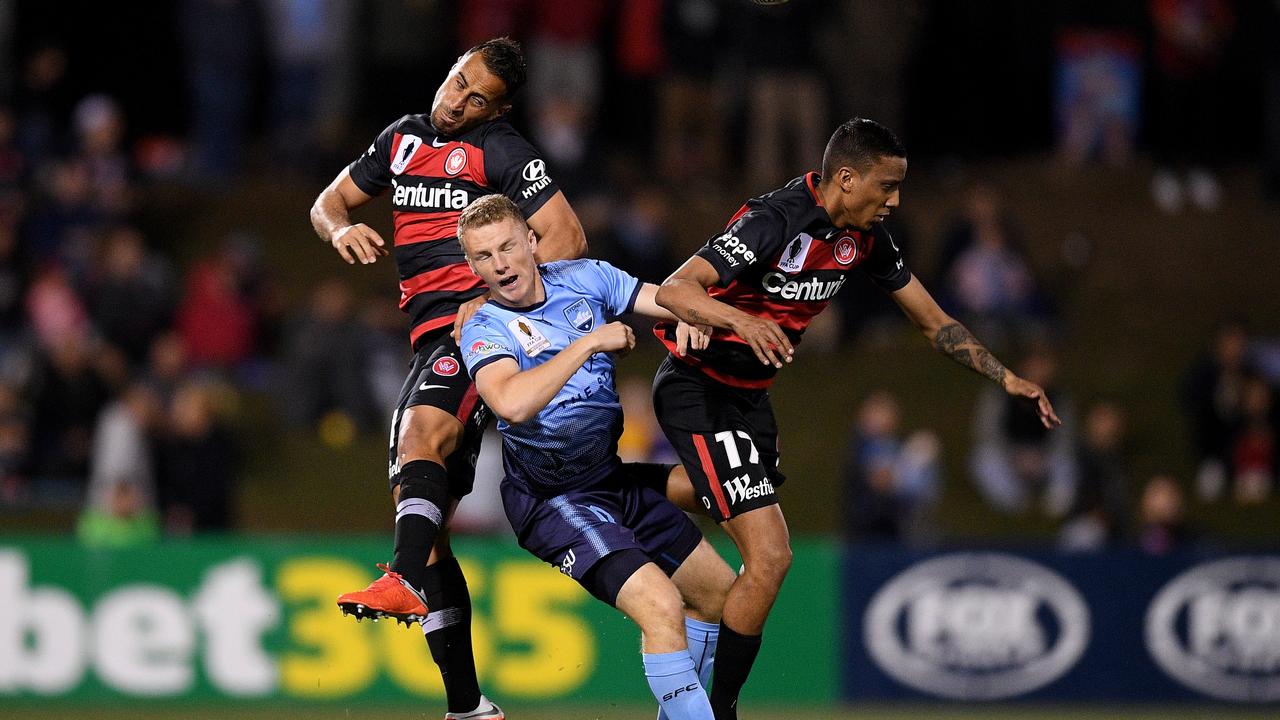 Trent Buhagiar of Sydney competes for possession with Tarek Elrich (left) and Keanu Baccus of the Wanderers