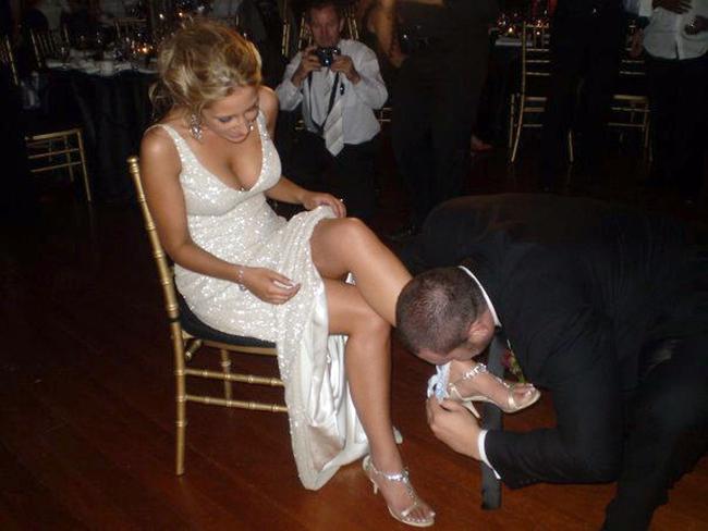 The loved-up groom removes the garter from the bride’s leg.