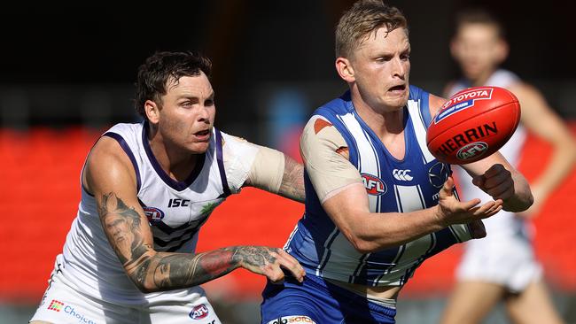 North Melbourne captain Jack Ziebell handballs under pressure.