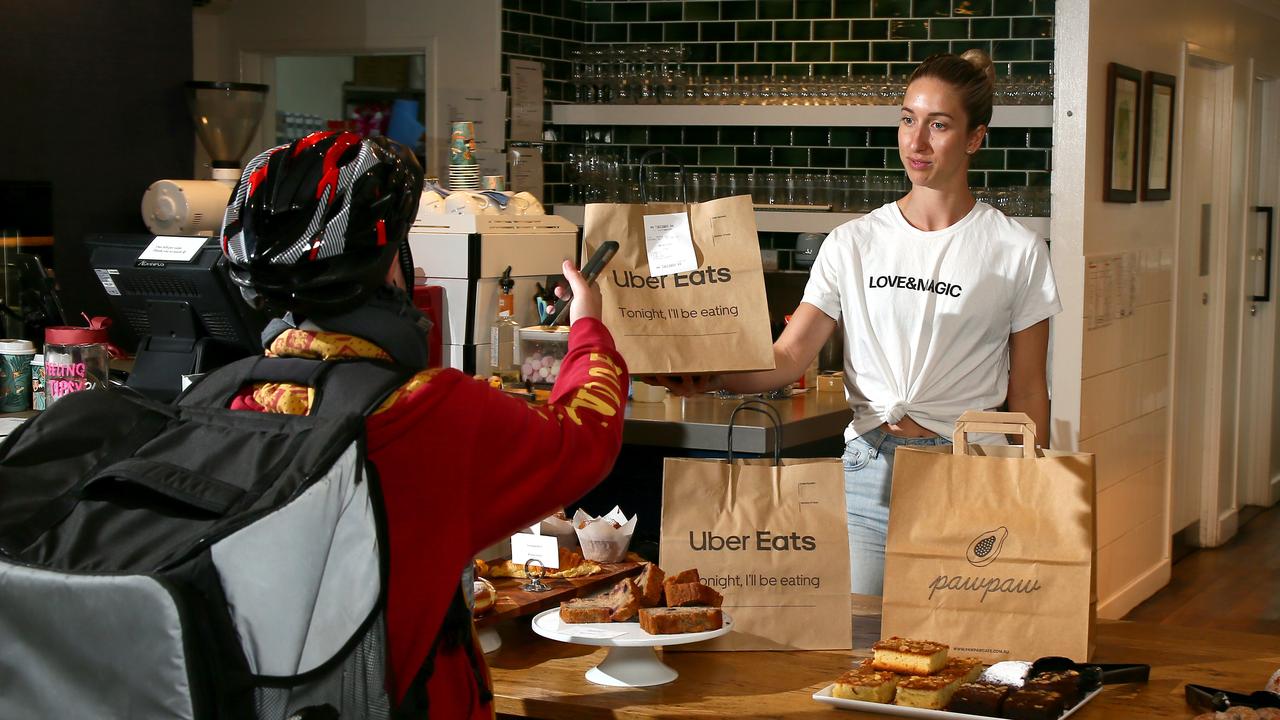 An UberEats rider picks up a delivery from Pawpaw Cafe in East Brisbane. Picture: David Clark/AAP