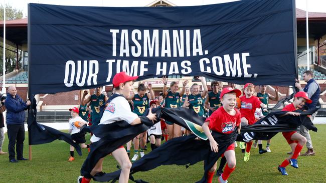 Junior Tasmanian players run though a banner at North Hobart Oval. Picture: Michael Willson/AFL Photos via Getty Images